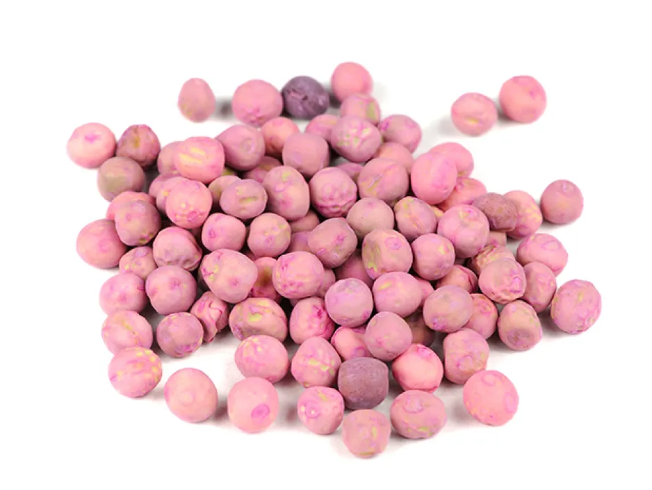 Pile of peas on a white background, covered with a pink powder.