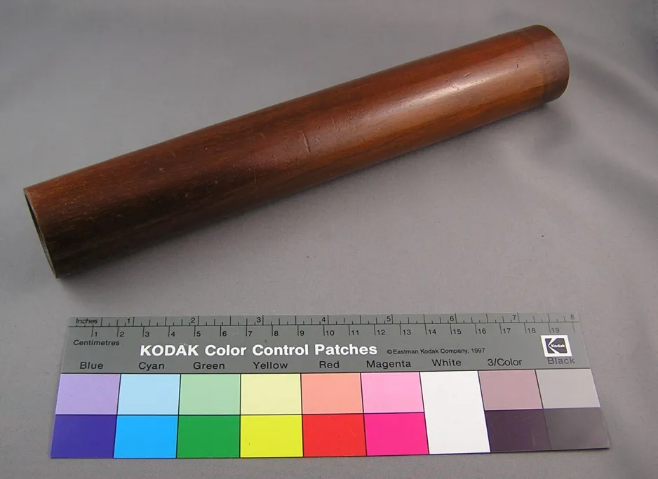 Cylindrical stethoscope manufactured of mahogany. It has a hole drilled through the core along the entire length of cylinder with a tapered opening at the opposite end. 
