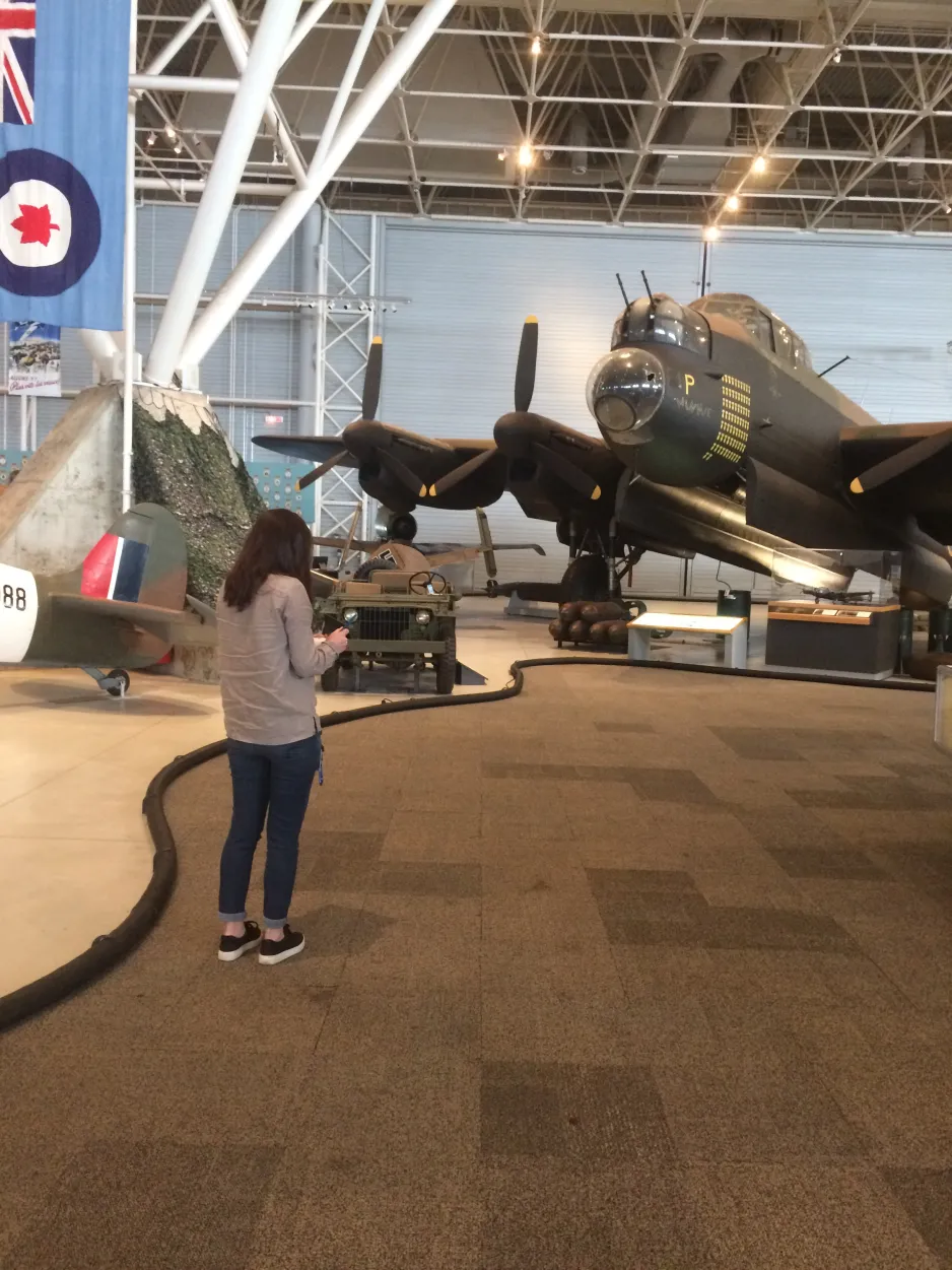 Intern Charlotte Clemens, standing with a clipboard in the Second World War section of the museum.