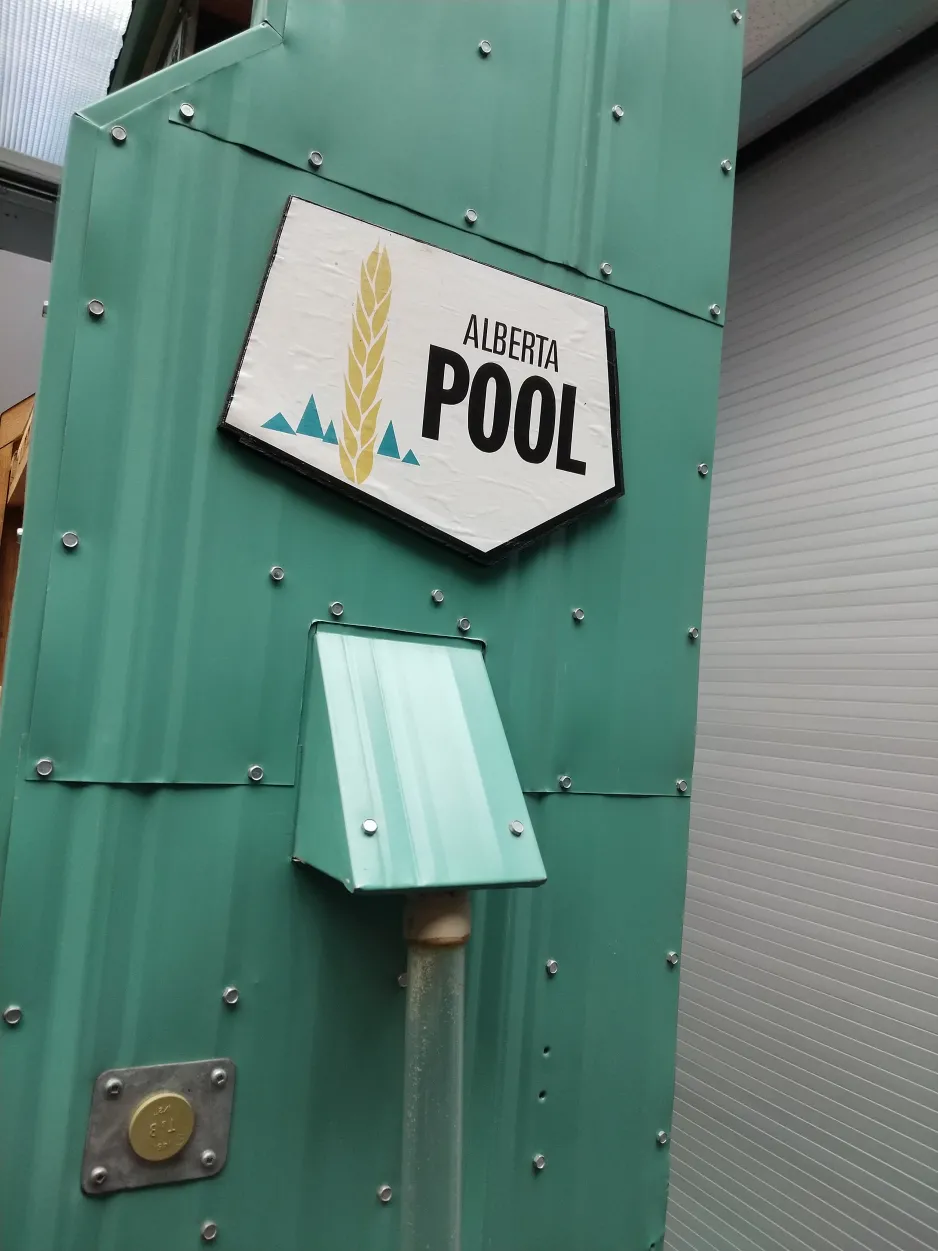 Close-up view of the Alberta Pool sign and the outside mechanism for depositing grain.