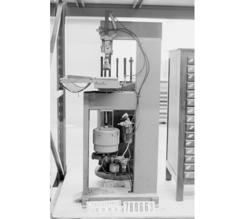 A black-and-white image of a small machine, used in the 1950s to make manipulate metal 