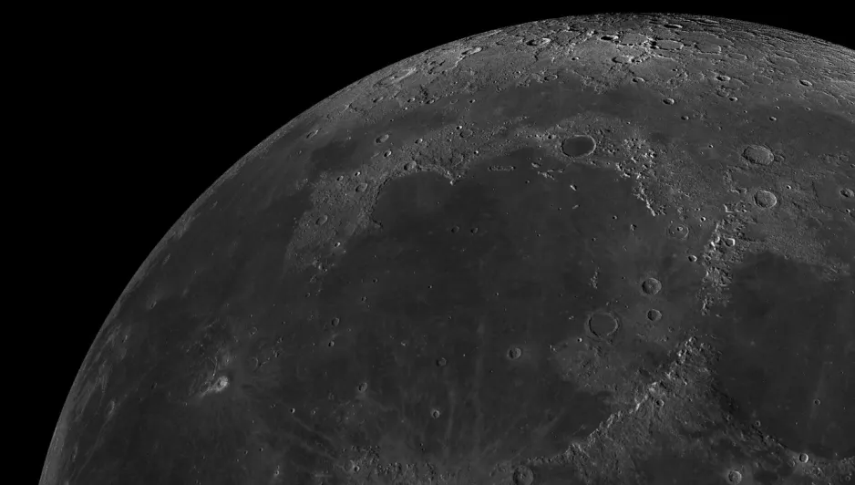 A texturally detailed image of the northwest region of the Moon’s nearside, depicted against the black background of space. 