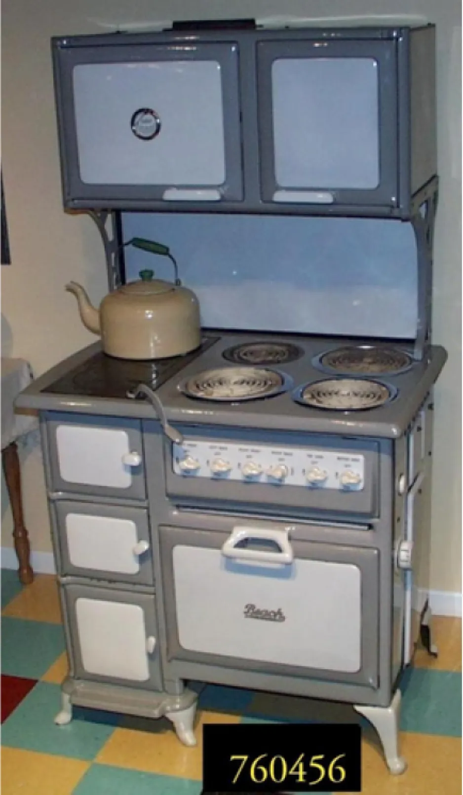A large grey and white range with four coiled electric elements, a large oven, and several small warming ovens. 