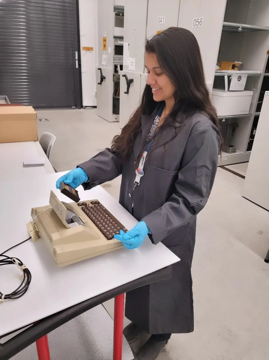 Researcher examining an Atari 400 Computer and Atari Basic Computer Language Cartridge.