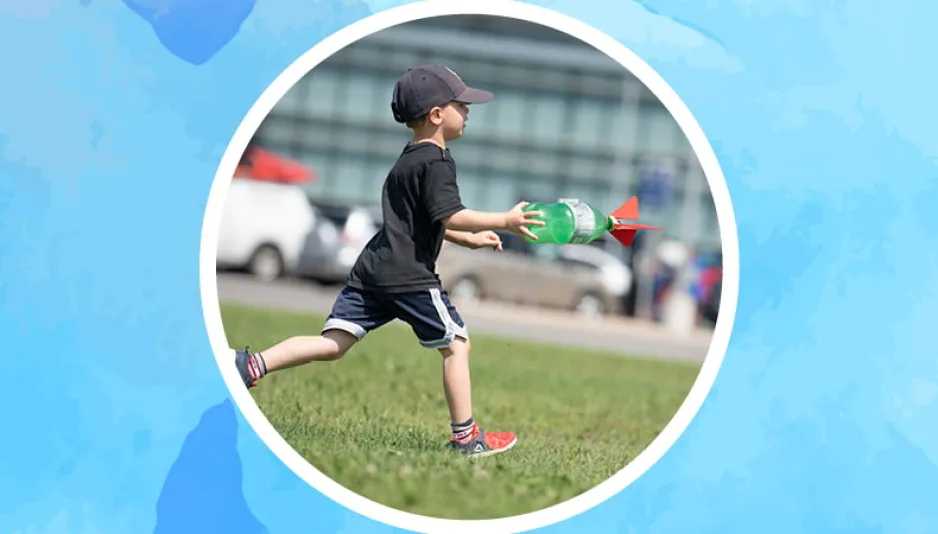 A boy is running outside on the grass with a coke bottle rocket, he is inside a circle against a medium blue background.