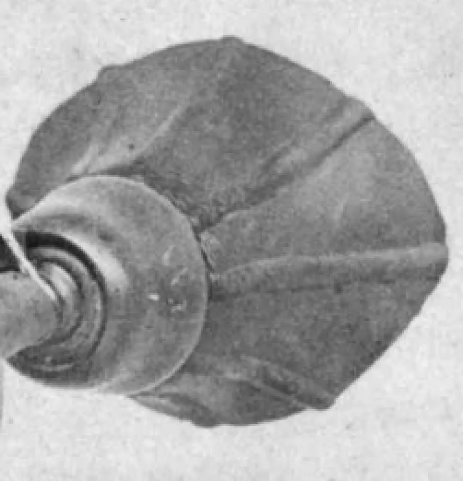 Cropped photograph of the 1874 ear phonautograph showing just the mouthpiece. The mouthpiece is black and resembles a cup with a fanned-out top. It has 9 or 10 evenly-spaced seams, running lengthwise, that give it a ribbed appearance. It is attached with a circular bracket at its base.