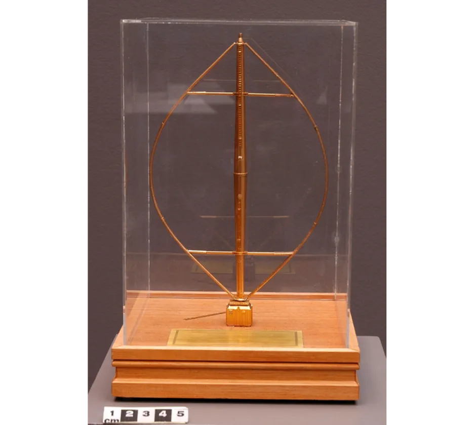 : Maquette synthétique de couleur or d'une éolienne à axe vertical montée sur une base carrée en bois.