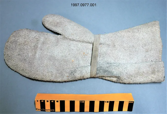 A single right oven mitt that is a dirty white in colour. The oven mitt is made of asbestos fibres