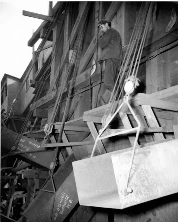 Un travailleur charge du minerai de fer dans les wagons d’un train du Canadien National pour un projet minier d’urgence en temps de guerre dans l’est du Canada afin qu’il soit transporté aux aciéries de Sydney, au Cap-Breton.