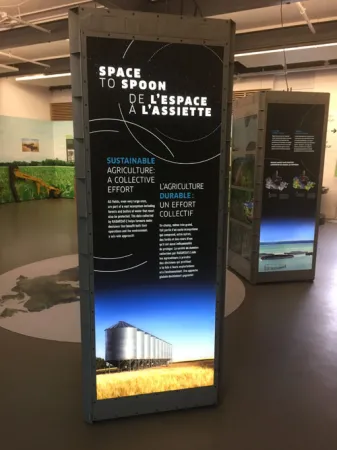 A view of an exhibition module; the words “Space to Spoon” are visible at the top and an image of silos is at the bottom.