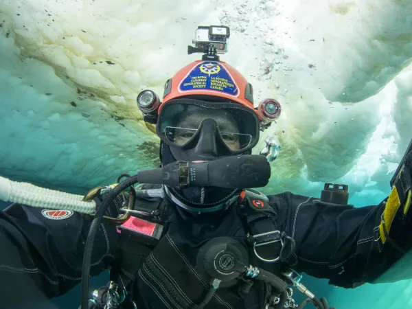 Jill Heinerth photographiant le dessous de la surface de la glace de mer près de l’île Bylot.