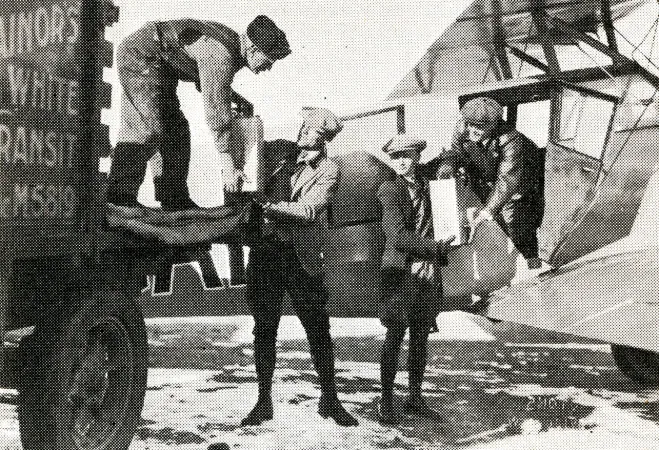 Déchargement de la nitroglycérine transportée de Shelby, Montana, à Calgary, Alberta, à bord du Stinson SB-1 Detroiter (violet?) de Great Western Airways Limited, février 1929. Anon., « -. » Canadian Aviation, avril 1929, 17.
