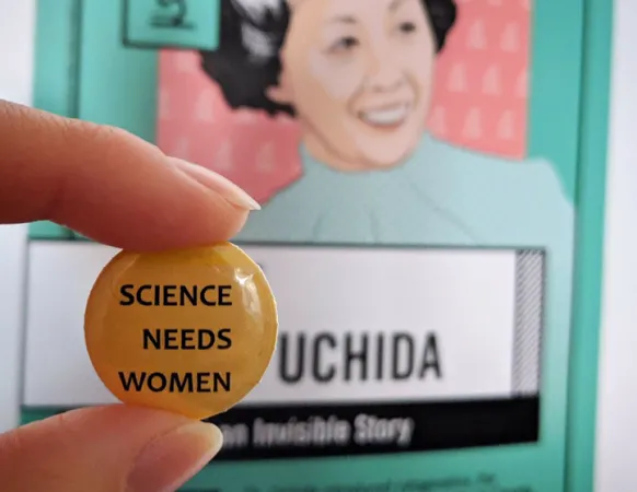 Épinglette portant la mention « Science Needs Women » devant une affiche d’Irene Ayako Uchida à Femmes en STIM.