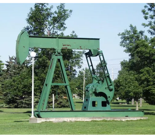 An oil pump jack in a grassy field.