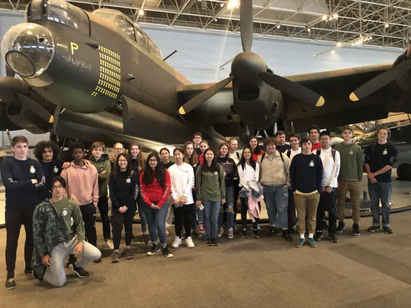 Un groupe d'étudiants pose devant le bombardier Lancaster au Musée de l'aviation et de l'espace du Canada