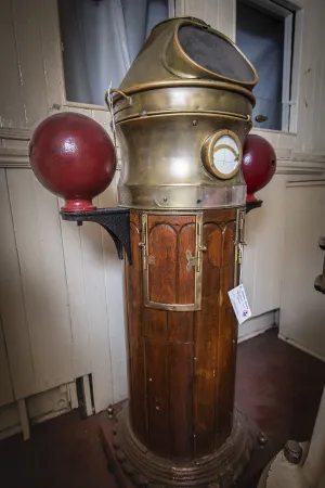 A tall wooden-and-brass column called the binnacle, which houses the ship's magnetic compass.