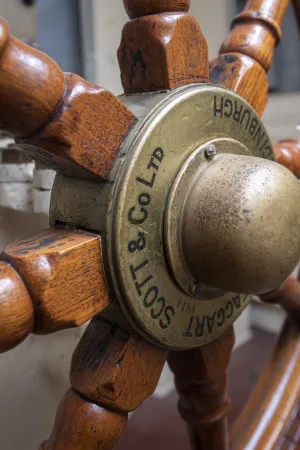A close-up view of the axle of the steering wheel, with the words “Scott and Co Ltd” etched in the brass.