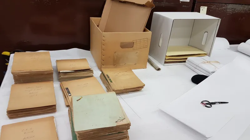 Des documents de la bibliothèque et du matériel d’emballage sont empilés sur une table.