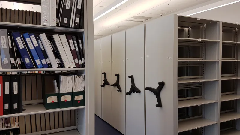 Étagères mobiles, dont certains rayons sont vides et d’autres remplis de documentation, dans la bibliothèque du Centre Ingenium