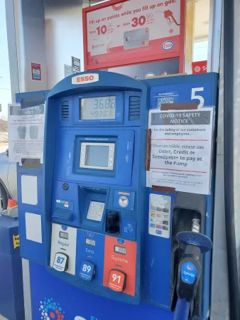 Pompe à essence avec panneaux d’avertissement concernant la COVID-19.