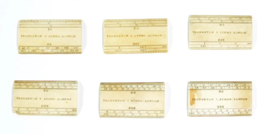 Six small rulers from a drafting kit are presented on a white background.
