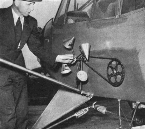 Walter Thomas Leavens examinant les coupes qui entraînent l’agitateur monté à l’intérieur de la trémie de l’avion léger / privé Piper J-5 Cub Cruiser utilisé par Leavens Brothers Air Services Limited. Anon., « Crop Dusting with a Cub. » Canadian Aviation, juillet 1945, 50.