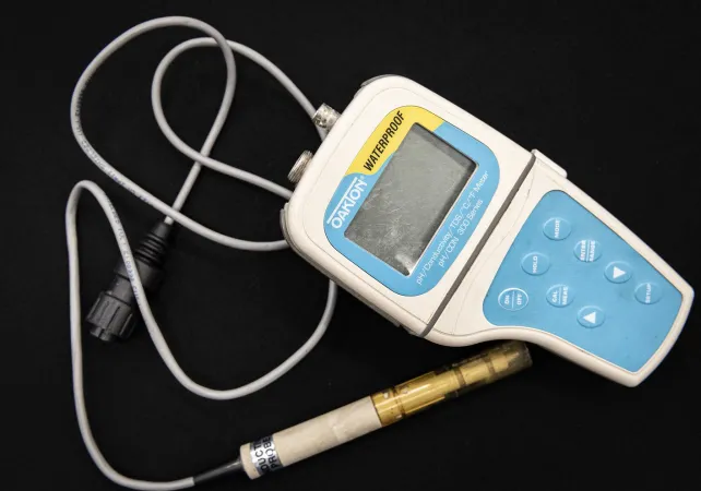 A waterproof blue and white handset connects to a probe via a white cable. 