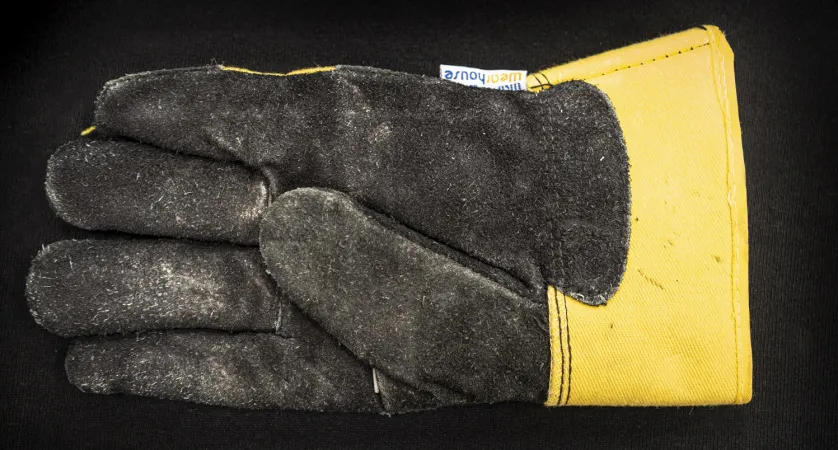 The finger part of the dusty glove is dark grey, while the rest of the hand is yellow.
