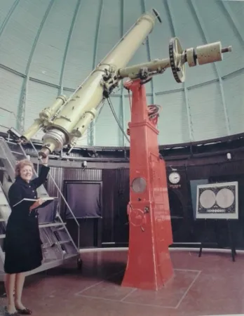 Mary Grey devant la lunette astronomique de l’Observatoire fédéral.