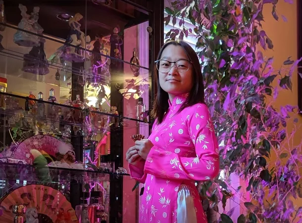A young woman wears a traditional Vietnamese dress in bright pink.