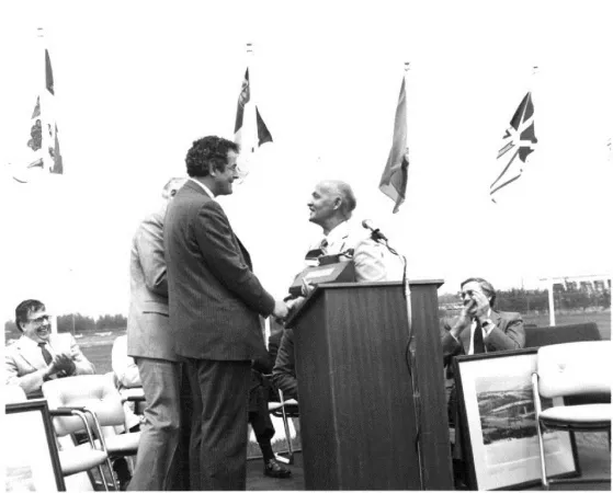 A beaming Robert William Bradford thanking Francis Fox, Minister of Communications, at the ceremony which signaled the start of the construction work on the new National Aviation Museum, Rockcliffe Park, Ontario, May 1983. CASM, 16020.