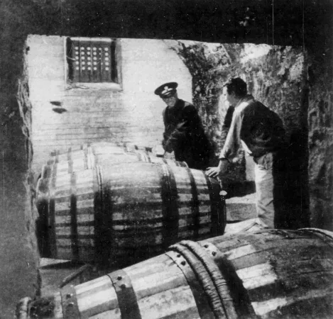 A Department of National Revenue custom inspector marking casks of port wine as an employee of a local agent of the English firm Hunt, Roote & Company, looks on, St. John’s, Newfoundland. Cyril Robinson, « Right Port for Port. » The Montreal Star Weekend Magazine, 6 December 1958, 26.