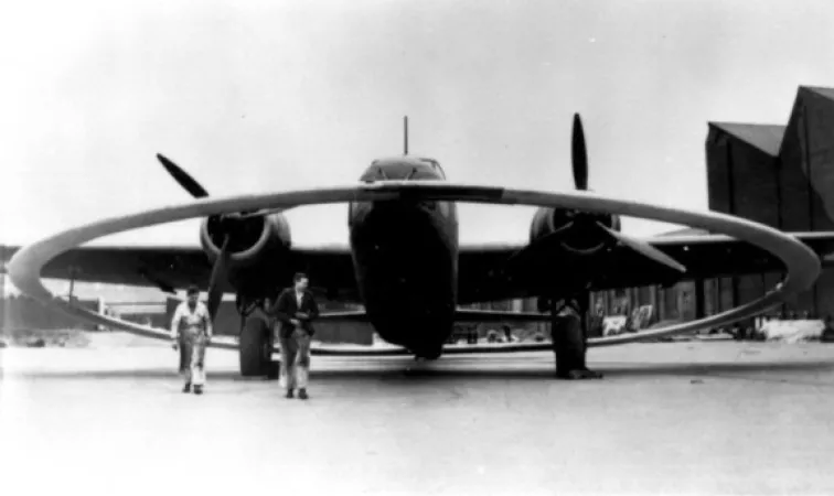 L’image est une photo noir et blanc montrant le devant d’un avion Vickers Wellington DWI. L’avion est équipé d’un anneau électromagnétique utilisé à l’époque pour faire exploser les mines qui flottaient sous la surface de l’eau.