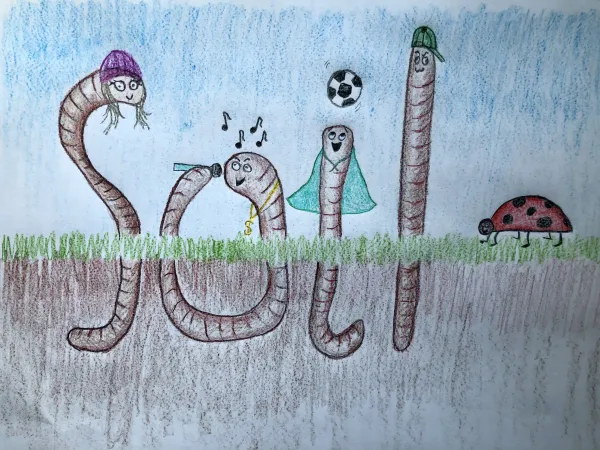 A drawing of four earthworm characters coming out of the dirt. Their bodies are drawn so they form the word soil.