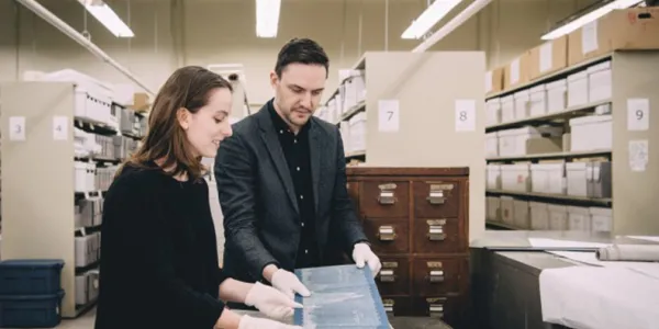 Cristina Wood, candidate à la maîtrise, et Tom Everrett, conservateur, examinent des documents historiques dans les archives du musée