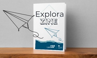 La couverture bleue et blanche d’un zine est présentée sur une tablette. On peut lire les mots « Explora ZINE ». Une illustration artistique d’un avion en papier se trouve sur le côté.