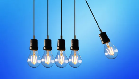 Five light bulbs hang in front of a blue background. The one furthest to the right hangs at a 25⁰ right of the vertical.