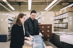 Cristina Wood and Tom Everrett examine records of tailwater elevations from the Domtar/E.B. Eddy/J.R. Booth Collection, which provided some of the historical data sets used in the “Songs of the Ottawa” project.