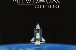 Une navette spatiale blanche et bleue quitte l'atmosphère terrestre et pointe vers le haut les mots "The IMAX experience"  [L'expérience IMAX]. Le fond de l'image est noir, le texte est blanc, et nous pouvons voir un océan bleu avec quelques nuages ​​blancs dans la Terre au bas de l'image.