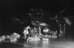 Personnel au sol chargeant des approvisionnements dans la soute à bombes d'un Avro Lancaster du 514e escadron de la Royal Air Force au cours de l'opération Manna, le largage de nourriture à la population néerlandaise affamée. 