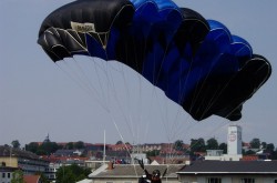 Le Danois Jan Bo Kristensen effectuant un atterrissage de précision avec un parachute-voile lors d’une compétition nationale organisée par la Dansk Faldskærms Union, Randers, Danemark, août 2005. Wikipédia.