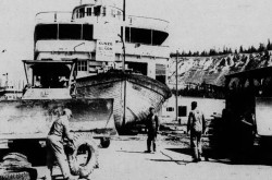 Le bateau fluvial à roue arrière SS Klondike à un stade précoce de son voyage vers Whiskey Flats South, Whitehorse, Territoire du Yukon. Anon., « Sidewalk Supers Size Up Sternwheeler. » Whitehorse Star, 23 juin 1966, 1.